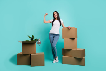 Full length body size view of nice attractive cheerful girl showing muscles packing things buyings pile stack of boxes isolated on bright vivid shine vibrant teal green blue turquoise color background