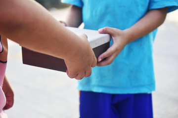 Naklejka premium Hand giving gift box,Underprivileged children in Southeast Asia
