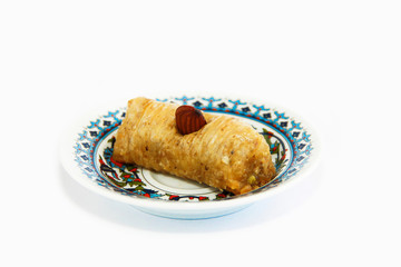 national oriental sweet baklava on a decorative plate on white background