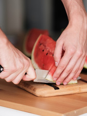 Obraz premium a man slices a watermelon into pieces. Close-up. 