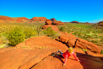 Kalaranga Lookout in Finke Gorge National Park, Northern Territory, Central Australia. Woman relaxing after hiking. Panoramic views of red sandstone amphitheatre. Red Centre Outback