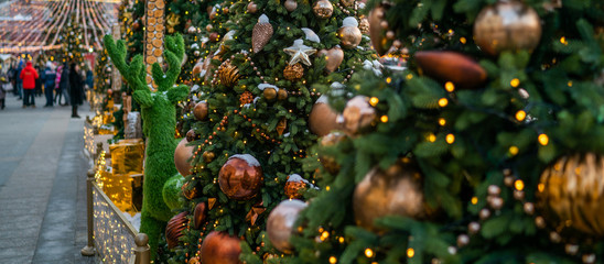 Urban street with Christmas decorations. Xmas lights and people walking around on the street. Blurred background. New Year Celebration concept.