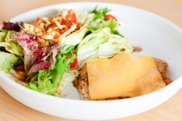 Grilled chicken steak with melted cheese and mixed salad