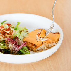 Grilled chicken steak with melted cheese and mixed salad