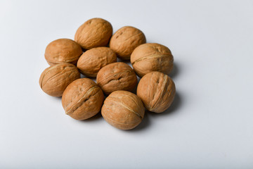 walnuts on a white background. Close up view of walnuts. Walnuts are 4 water, 15 protein, 65 fat and 14 carbohydrates, including 7 dietary fiber. In a reference portion of 100 grams.