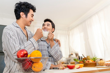 Asian homosexual couple drinking milk at kitchen.Concept LGBT gay.