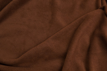 Fabric fleece brown view from the top. Texture of textile fleece bedspread.