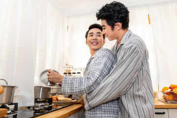 Asian homosexual couple cooking in the kitchen together.Concept LGBT gay.