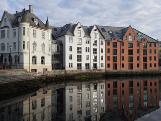 Secessionist buildings of european Alesund town reflected in water at Romsdal region in Norway