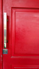 Silver door handle in red wood painted door