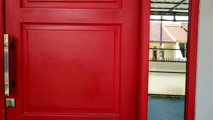 Silver door handle in red wood painted door