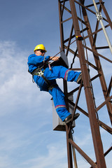 Electrician programs substation on a lamppost with a laptop