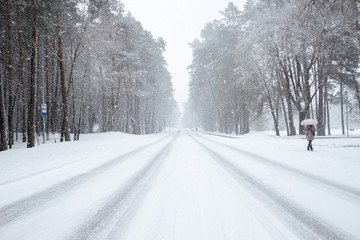 Winter time. Snow-covered road during snowfall.