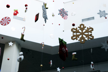 Abstract design of public premises for the new year. Snowflakes and Christmas toys hang on threads in a supermarket, airport or station. Selective focus, shallow depth of field. background copy space.
