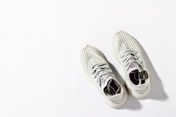 Sneakers on a white background under the morning sun. The concept of running, fitness, cross fit. Morning running. Natural light. Flat lay, top view