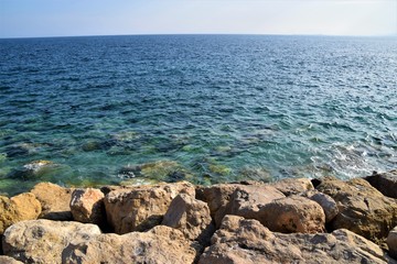 Fototapeta na wymiar Blue sea, sky horizon and rocky coast summer scenery