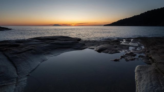 Time lapse with sunrise at the rocky coastline of Thasos island, Greece