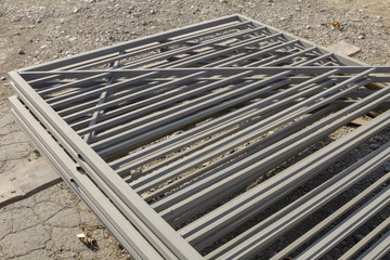 Manufactured metal fences, stacked and painted in gray.