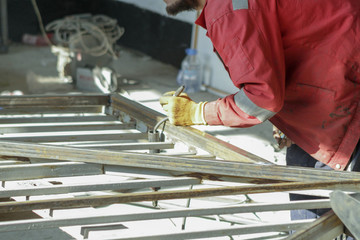 The process of measuring pipes before welding in the manufacture of metal fencing in the workshop