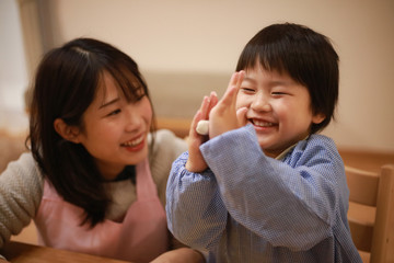ねんどで遊ぶ男の子と保育士イメージ