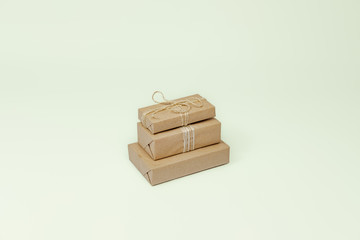 Presents in wrapped in recycled paper, copy space. Holiday gifts wrapped in sustainable natural package in isolated background