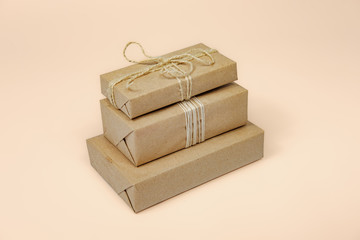 Presents in wrapped in recycled paper, copy space. Holiday gifts wrapped in sustainable natural package in isolated background