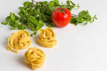Durum wheat pasta on a white background. Tomatoes and mint.