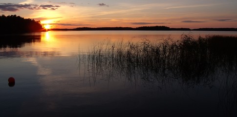 Obraz premium in the calm lake, the golden sunset is reflected
