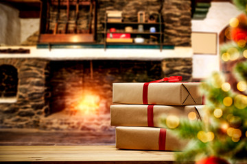 Brown xmas gifts with red ribbon and free space for your decoration. Fireplace in home interior and xmas tree 