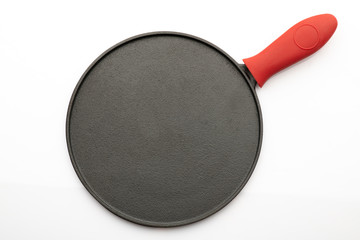 Top View of Seasoned Cast Iron Pan on White Background with Red Silicon Handle Grip