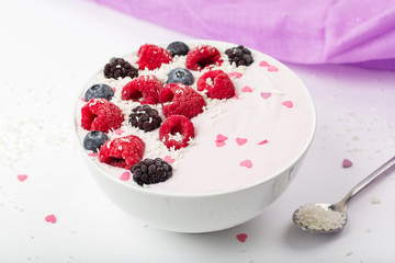 Breakfast smoothie bowl with yogurt, fresh raspberries, blueberries, BlackBerry, coconut flakes and granola. Healthy food. 