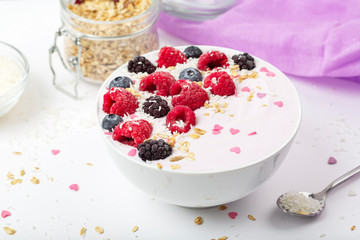 Breakfast smoothie bowl with yogurt, fresh raspberries, blueberries, BlackBerry, coconut flakes and granola. Healthy food. 