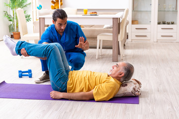 Young male doctor visiting old patient at home