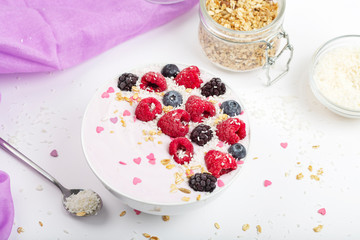Breakfast smoothie bowl with yogurt, fresh raspberries, blueberries, BlackBerry, coconut flakes and granola. Healthy food. 
