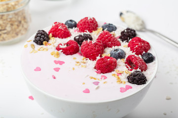 Breakfast smoothie bowl with yogurt, fresh raspberries, blueberries, BlackBerry, coconut flakes and granola. Healthy food. 