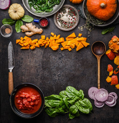 Vegetarian herbst and winter cooking background. Seasonal vegetables, herbs and spices with kitchen knife and wooden spoon. Frame. Top view. Copy space