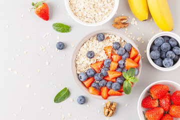 Healthy smoothie bowl with granola, fresh strawberries, blueberries, bananas, yogurt and mint. Healthy food, snack or breakfast. 