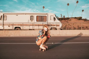Fotobehang retro stijl skater meisje met een camper op de achtergrond. californische levensstijl © 2mmedia