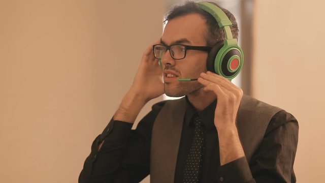 business man interpreter teacher wearing headset looking at laptop screen making notes