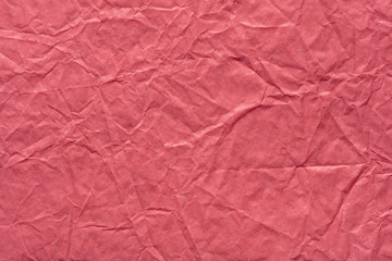 Crumpled paper background in saturated pink color as part of your greeting gift.