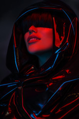 Beauty portrait of woman with black latex and red light on face