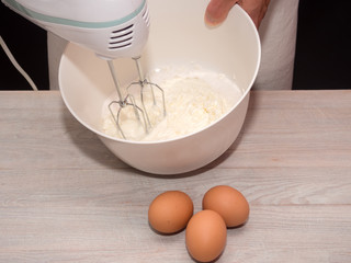 Fototapeta na wymiar Beating yogurt and sugar with mixer. Making Yogurt Cake.