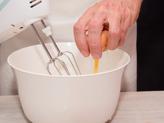 Cracking egg into bowl. Making Yogurt Cake.