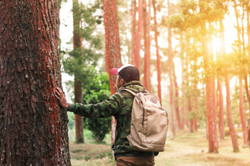 Naklejka premium Traveler man with backpack standing near tropical jungle at sunny day