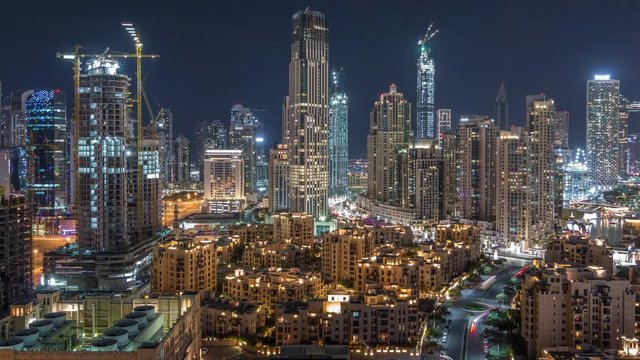 Beautiful skyline of Dubai downtown and Business bay with modern architecture night timelapse. Aerial view of Dubai illuminated skyscrapers from above with traffic on the road