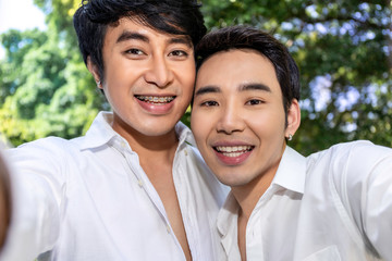 Young Asian homosexual couple taking self portrait with smart phone.Concept LGBT gay.