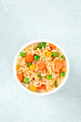 Instant noodles with vegetables in a plastic cup, shot form above with a place for text