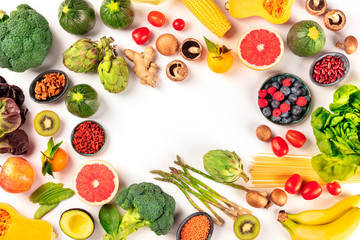 Vegan food. Healthy diet concept. Fruits, vegetables, pasta, nuts, legumes, mushrooms, shot from the top on a white background, forming a frame with a place for text. A flat lay composition
