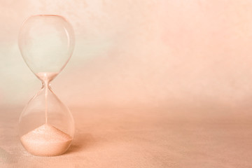 An hourglass with sand falling through with a place for text. Old age, nostalgia concept with copy space, sepia toned image