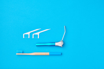 Dentist tools over blue background top view copy space flat lay. Tooth care, dental hygiene and health concept.